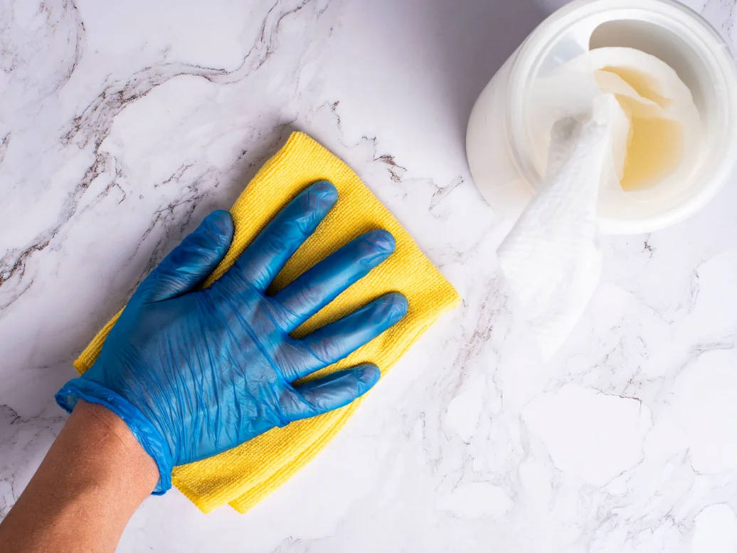 Cleaner wiping down a bright, modern kitchen